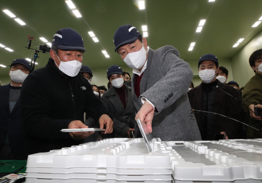 윤석열 국민의힘 대선후보가 30일 충북 청주시 청원구에 위치한 우수강소기업 클레버를 방문해 관계자와 전기차용  2차전지를 살펴보고 있다. 연합뉴스